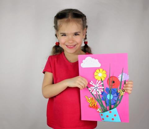 A young girl holding handmade art