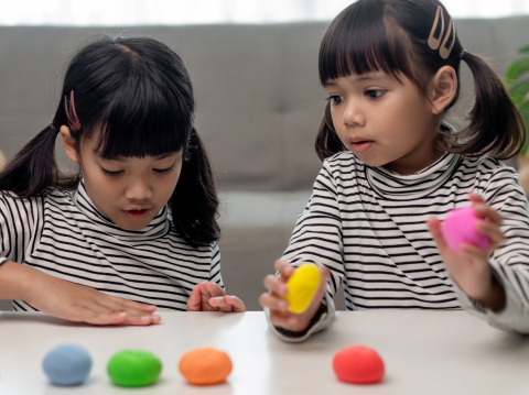 two girls playing with playdoh