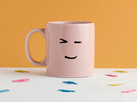 mug with funny face drawn on it