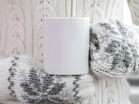 someone holding empty mug with mittens