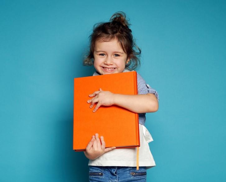 A girl holding an orange book