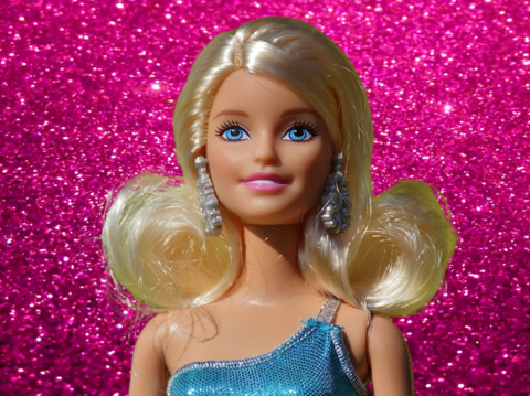 Barbie doll with pink glitter background