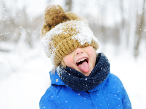 child sticking tongue out to catch snow