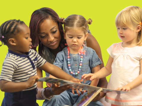 adult looking at book with kids